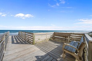 A wooden boardwalk leading to a beach with a bench and railing. - Bird’s Nest | Ocean View Condo w/ Balcony (Surf City)