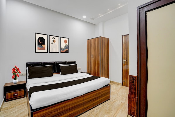 A modern bedroom with a bed, wooden wardrobe, and artwork on the wall. - Saver Double White Solitaire (Ludhiana)