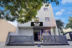 A modern hotel with a sign reading 'HOTELO' and 'Company Serviced.'