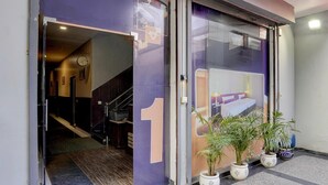 A hotel entrance with a number '1' sign, a staircase, and potted plants. - Saver Double White Solitaire (Ludhiana)