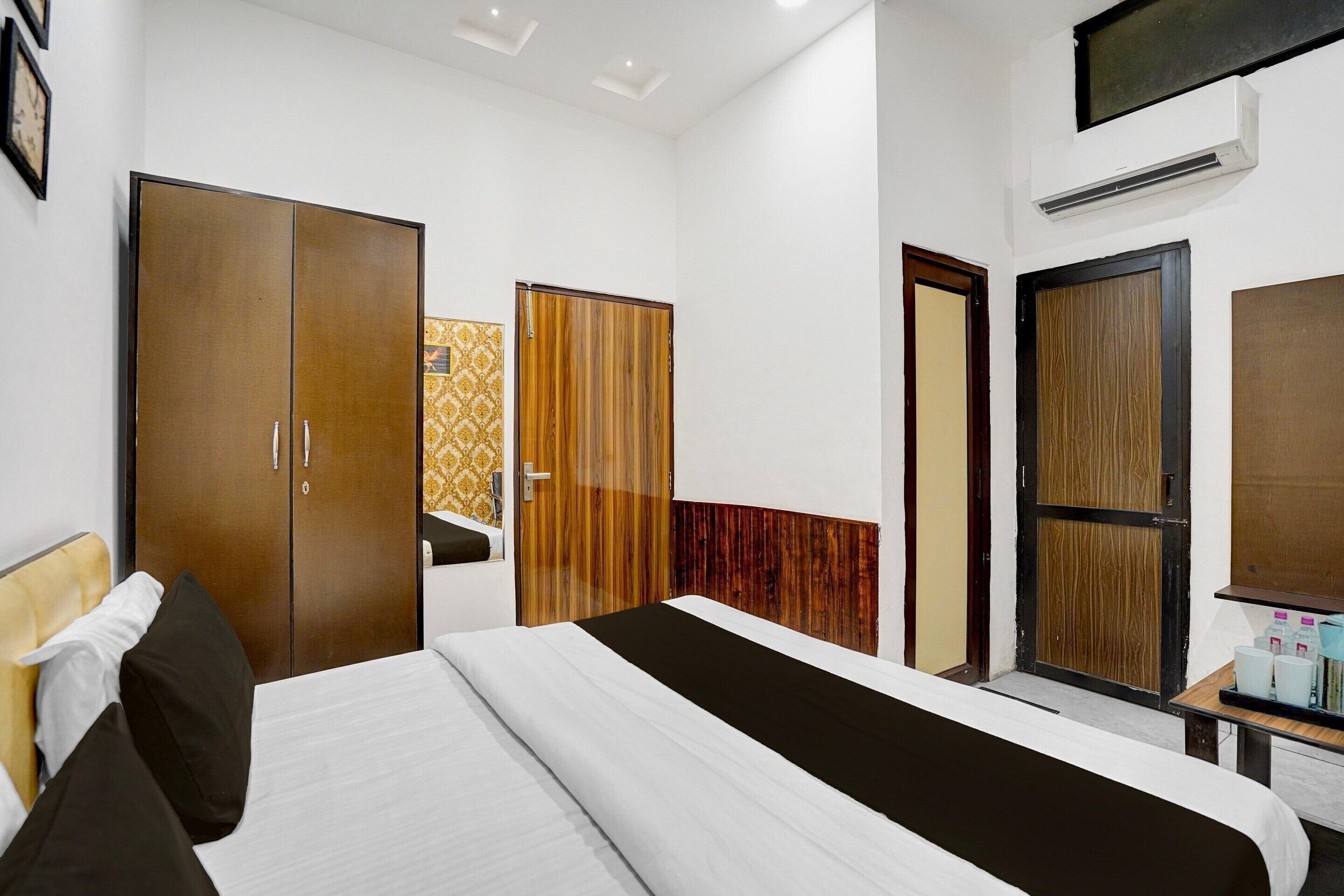 A hotel room with a bed, wardrobe, and a small table with items on it.