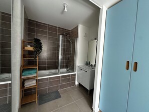 A bathroom with a shower, a sink, a mirror, and a towel rack. - A family escape among meadows, birds and gardens (Chantepie)