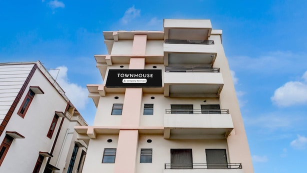A multi-story building with a sign reading 'TOWNHOUSE & Company Serviced.' - Classic With Balcony Beltola Tiniali Pratishtha (Guwahati)