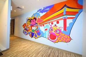 A hallway with a colorful mural featuring cartoon characters and a dragon. - Ehouse Hotel Xining Banch (Taipei)