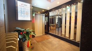 A hotel reception area with a digital map display, a potted plant, and a mirror wall. - Ehouse Hotel Xining Banch (Taipei)