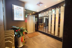 A hotel reception area with a digital map display, a potted plant, and a mirror wall. - Ehouse Hotel Xining Banch (Taipei)