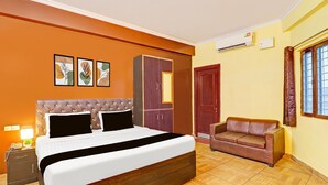 A bedroom with a bed, a wardrobe, a sofa, and a nightstand. - Saver Double Sunshine Guest House (Dehradun)