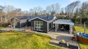 A modern house with a patio, a hot tub, and a covered outdoor seating area. - "Ascan" - 300m to the fjord by Interhome (Tarm)