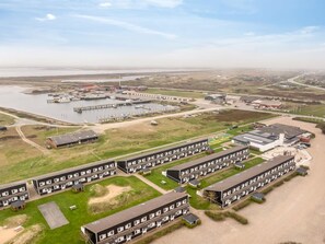 Un hotel costero con edificios de varios pisos, un puerto deportivo y un amplio estacionamiento.