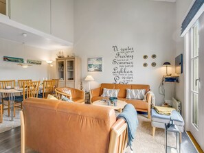 A modern living room with a sofa, chairs, a dining table, and a wall with text. - "Melvin" - 50m to the fjord by Interhome (Vestervig)