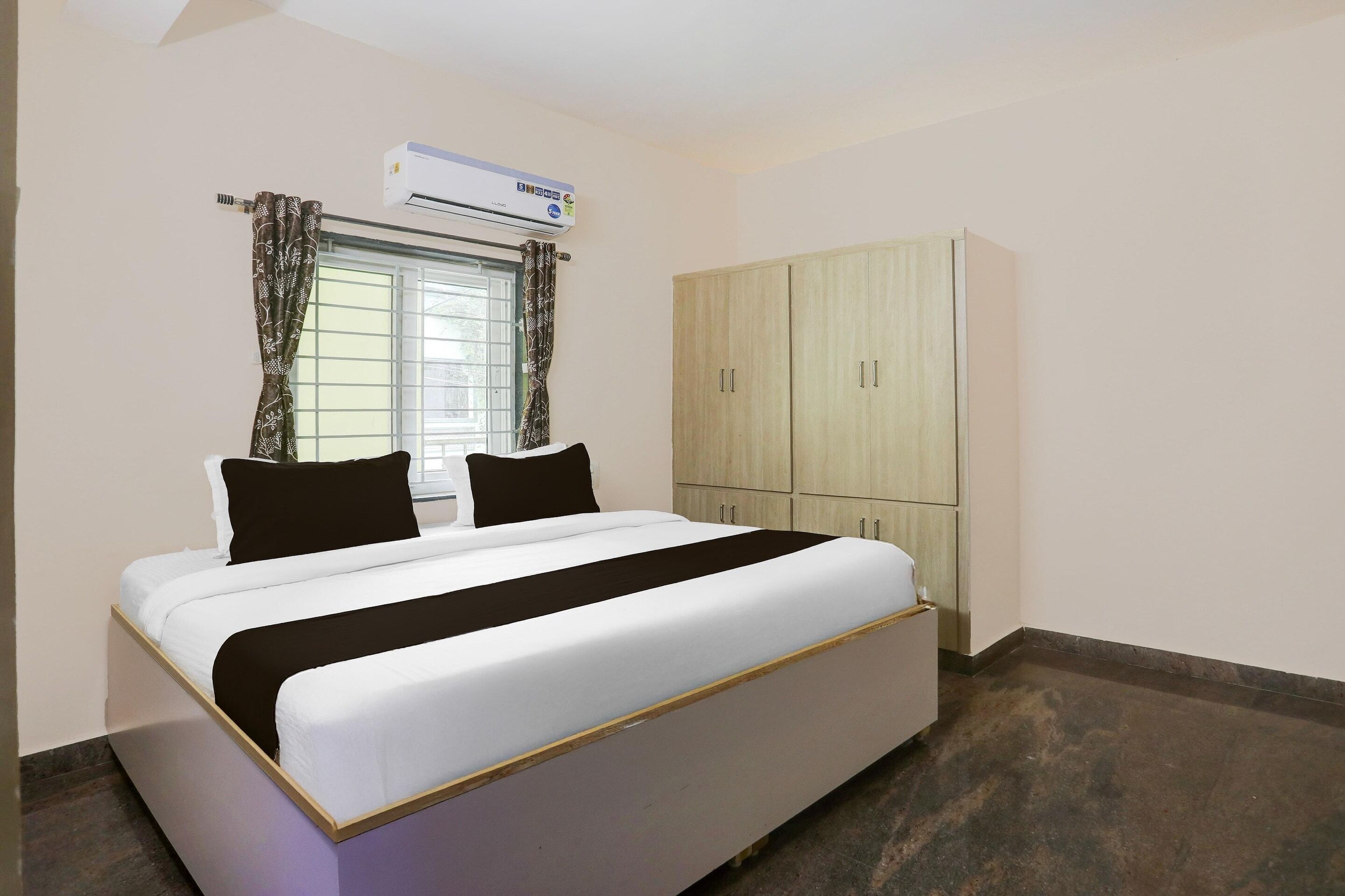 Un dormitorio con cama, aire acondicionado, ventana con cortinas y armario.