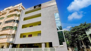 A multi-story building with balconies, a sign reading 'Collection,' and a gated entrance. - Deluxe y Stay Home Stay (Tirupati)