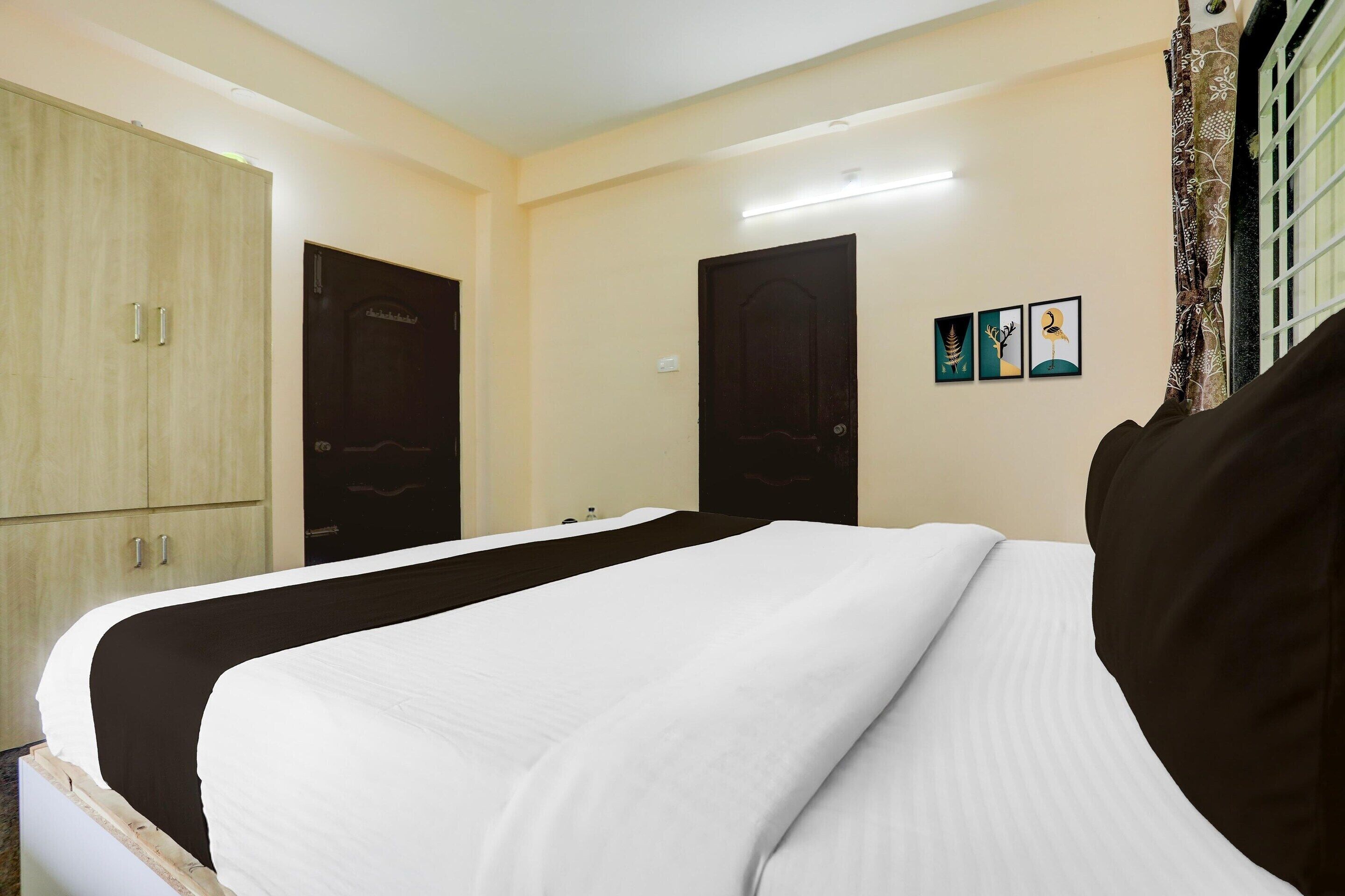 Una habitación de hotel con cama, armario y puerta.