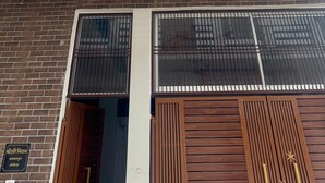 Un immeuble à plusieurs étages, doté d’une façade en briques, de grandes fenêtres avec des barreaux en métal et d’un balcon agrémenté de balustrades.