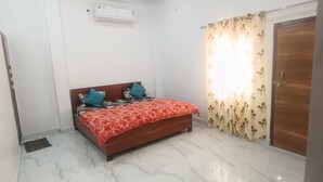 Une chambre à coucher avec un lit, une armoire et une fenêtre avec des rideaux.