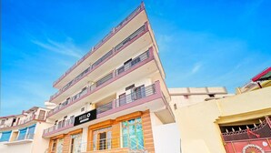 A multi-story hotel with balconies, a staircase, and a sign indicating it is a hotel. - Saver Single Sunshine Guest House (Dehradun)