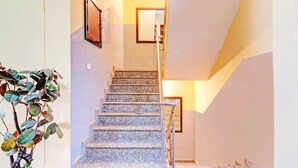 A staircase with a handrail, a potted plant, and a framed picture on the wall. - Saver Single Sunshine Guest House (Dehradun)