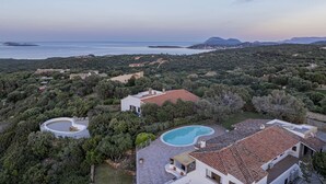 An aerial view of a property with a swimming pool, terraced houses, and a view of the sea. - Villa Junia by Klodge, pool & seaview in San Pantaleo (San Pantaleo)