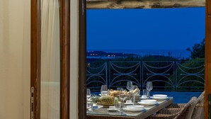 An outdoor dining area with a table set for a meal, overlooking a scenic view. - Villa Junia by Klodge, pool & seaview in San Pantaleo (San Pantaleo)