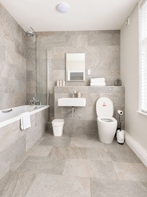 Ein modernes Badezimmer mit Dusche, Badewanne, Waschbecken und Toilette.