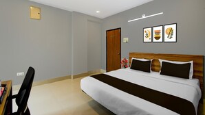 A hotel room with a bed, a desk, and a chair. - Super Townhouse Cherlapally Bus Terminal (Hyderabad)