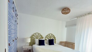 Une chambre à coucher avec un lit, une table de chevet, une lampe et un tapis à motifs.