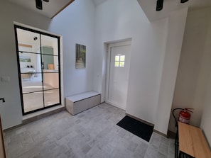 A modern interior with a bench, a door, and a fire extinguisher.