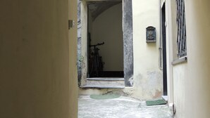 Un callejón estrecho que conduce a la entrada de un edificio, con una bicicleta estacionada allí.