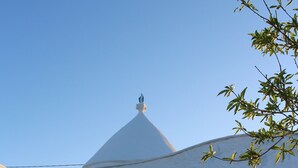 A white building with a dome roof, a door, and a window. - Cozy medieval trullo for couples and families seeking tranquility. (OSTUNI)