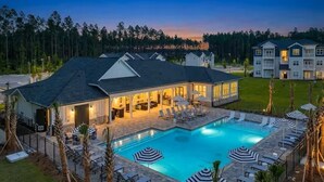 A hotel with a swimming pool, lounge chairs, and umbrellas. - Family Cinema Escape · Salt Pool · Gym · Sleeps 8 (Yulee)