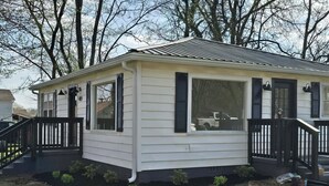 Une maison de plain-pied avec un porche, un garage et un petit jardin devant.