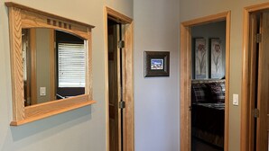 Ein Korridor mit Holztüren, einem gerahmten Bild an der Wand und einem Teppichboden.