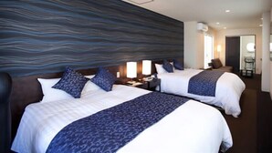 A hotel room with two beds, a large wall mural, a desk with a lamp, and a chair. - Onomichi Minato Hotel (Onomichi)