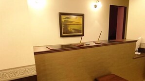A reception desk with a framed picture, a small table, and a door. - Onomichi Minato Hotel (Onomichi)