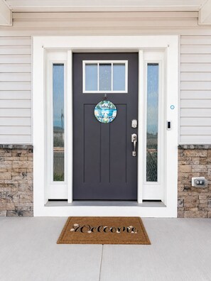 A dark grey front door with a welcome sign, a mailbox, and a doormat. - 3 En-Suite Beach House - 5 minutes Walk to Beach - Entire townhome - Sleeps 10 (Ocean City)