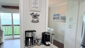 Eine Küche mit Marmorarbeitsplatte, Kaffeemaschine und Schränken.