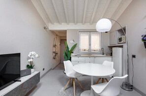 Eine moderne Küche mit weißen Schränken, einem eingebauten Backofen und einem Fenster mit Vorhängen.