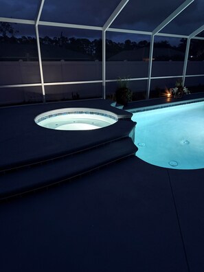 Ein Whirlpool mit kreisförmigem Design, umgeben von einer überdachten Fläche mit Stufen zum Wasser.