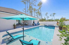 Ein Schwimmbecken mit Liegestühlen und einer Terrassenfläche.