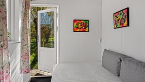 A bedroom with a bed, a door leading outside, and two framed artworks on the wall. - "Bisera" - 3km from the sea by Interhome (Rødby)