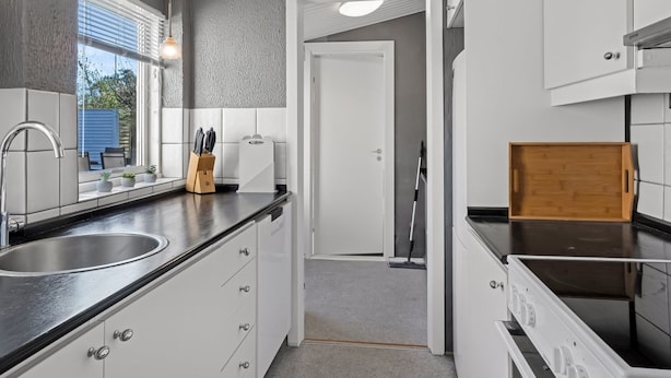 A modern kitchen with a sink, countertop, cabinets, and a wooden tray. - "Bisera" - 3km from the sea by Interhome (Rødby)