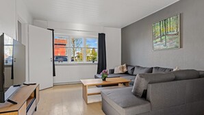 A modern living room with a grey sofa, a wooden coffee table, and a TV on a wooden stand. - "Bisera" - 3km from the sea by Interhome (Rødby)