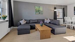 A modern living room with a sectional sofa, a wooden coffee table, and a painting on the wall. - "Bisera" - 3km from the sea by Interhome (Rødby)
