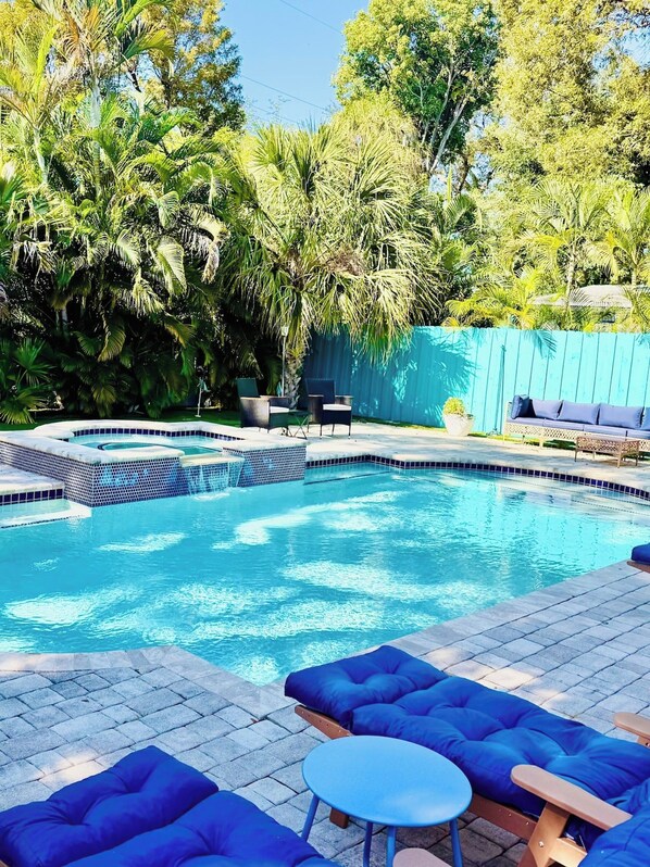 A swimming pool with blue lounge chairs and a small table. - MerManor - An Iconic Merman Pool Oasis (Fort Lauderdale)