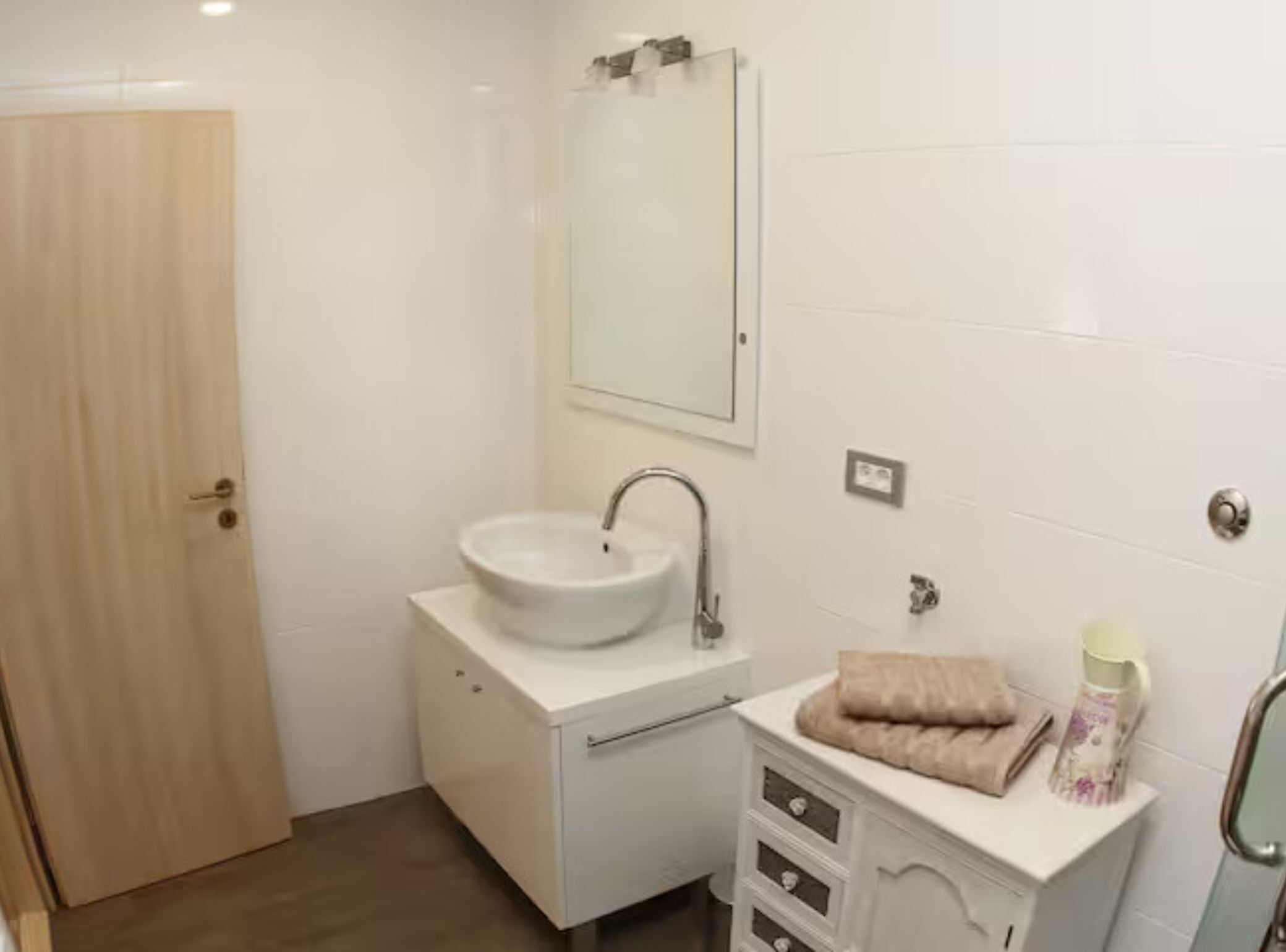 Un baño con lavamanos, espejo y mueble.