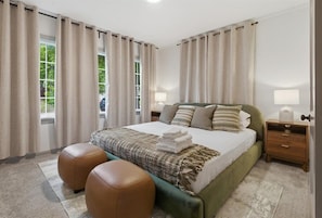 A bedroom with a bed, two nightstands, a window, and curtains.