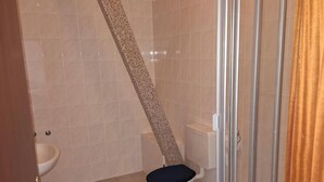 A bathroom with a toilet, bidet, and shower area. - Weißes Roß (Crossen an der Elster)