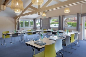 A conference room with tables, chairs, and hanging lights. - Kyriad Marseille Est - Aubagne Gemenos (Gemenos)