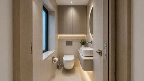 A modern bathroom with a toilet, sink, and mirror. - Mayfair Loft (London)