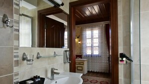 A bathroom with a white sink, mirror, and tiled walls.